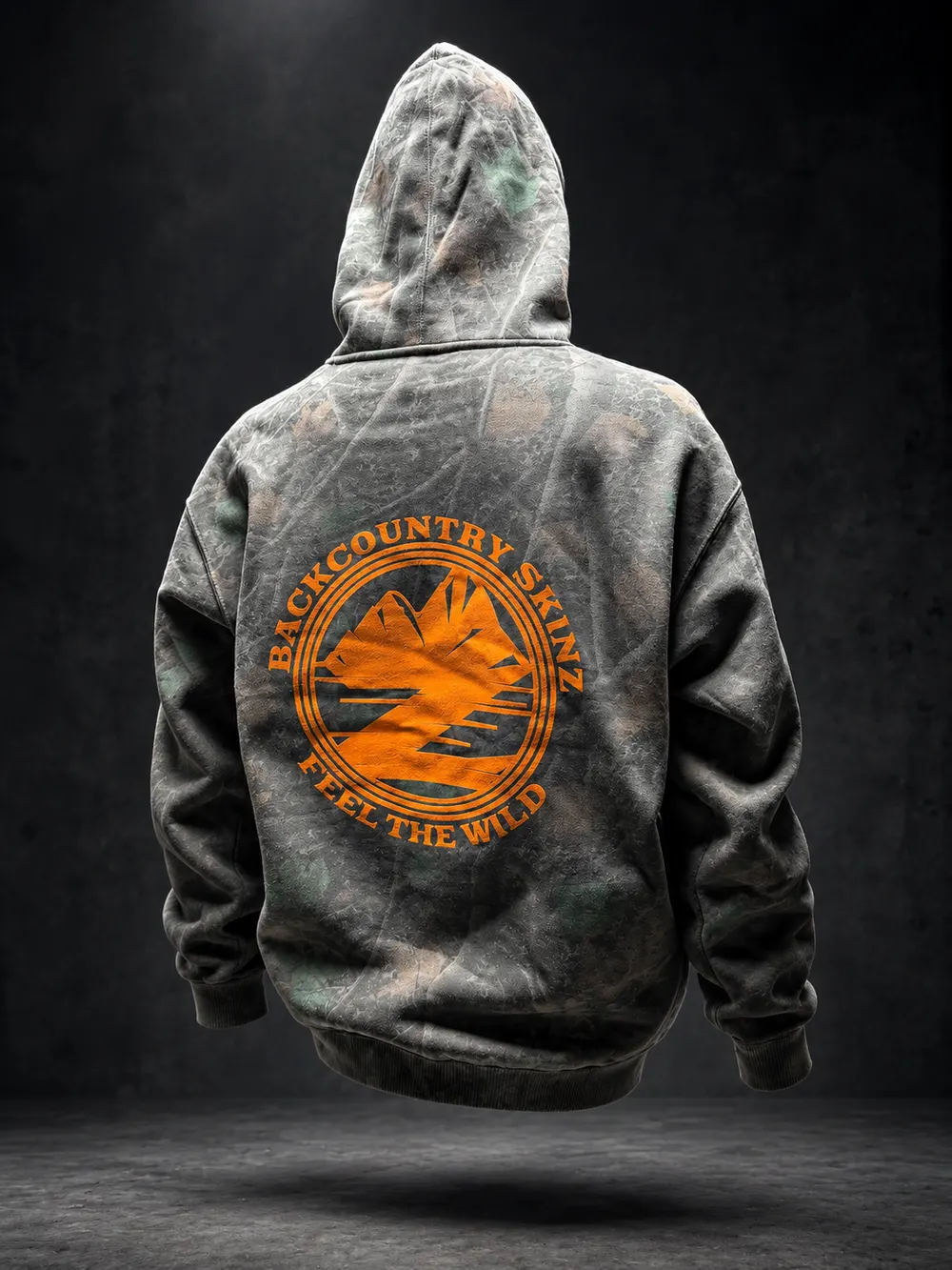 Back of a camo Backcountry Skinz hoodie with an orange Feel the Wild screen print
